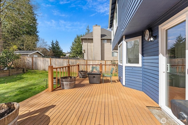 wooden deck with an outdoor fire pit, a fenced backyard, and a yard