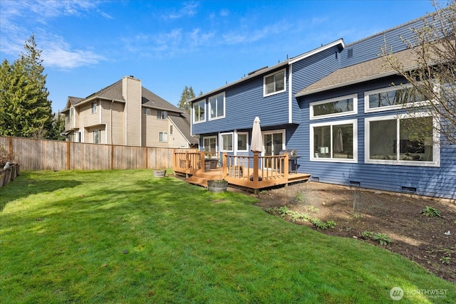 back of property featuring fence, a deck, and a yard