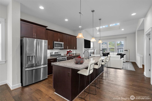 3727 Oakwood St SE, Olympia, WA 98513 - kitchen featuring appliances with stainless steel finishes, dark brown cabinetry, a kitchen bar, dark wood-style floors, and recessed lighting