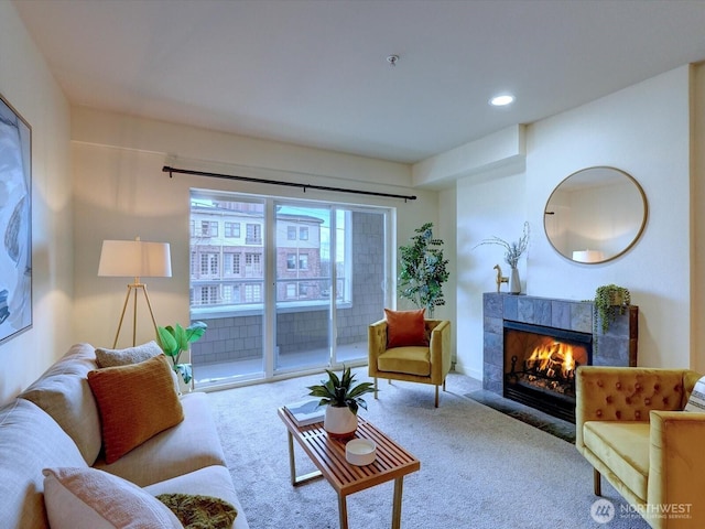 carpeted living area featuring recessed lighting and a tile fireplace