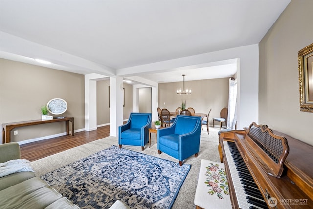living room featuring baseboards, an inviting chandelier, and wood finished floors
