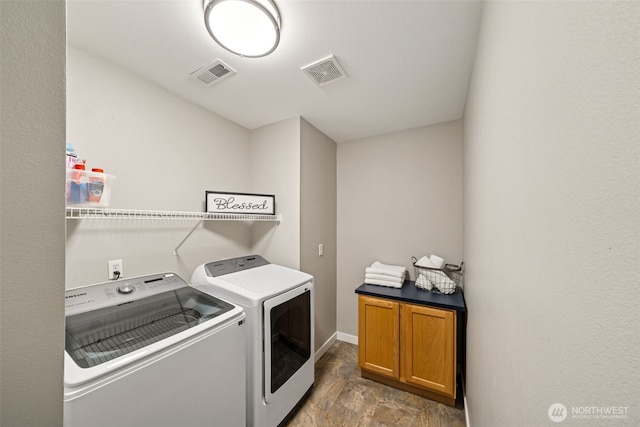 laundry area featuring visible vents, cabinet space, and separate washer and dryer