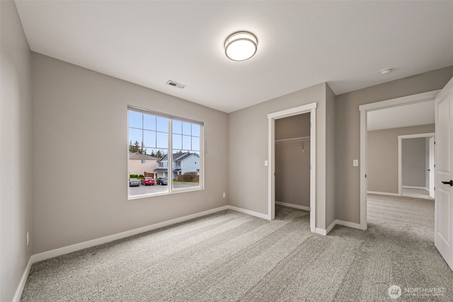 unfurnished bedroom featuring visible vents, baseboards, carpet, and a closet