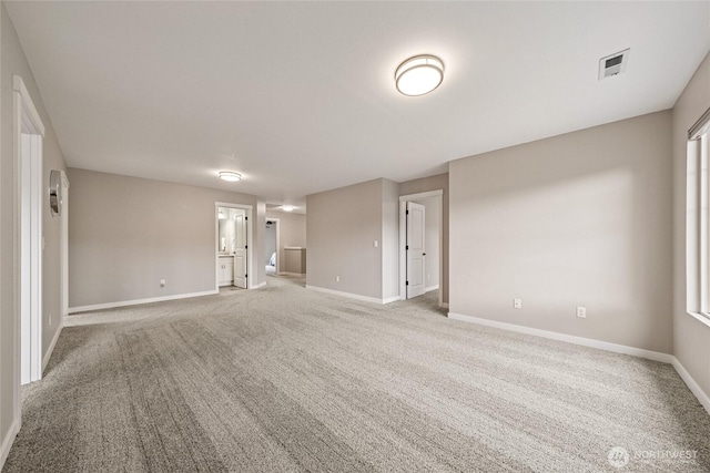 unfurnished room featuring visible vents, light colored carpet, and baseboards