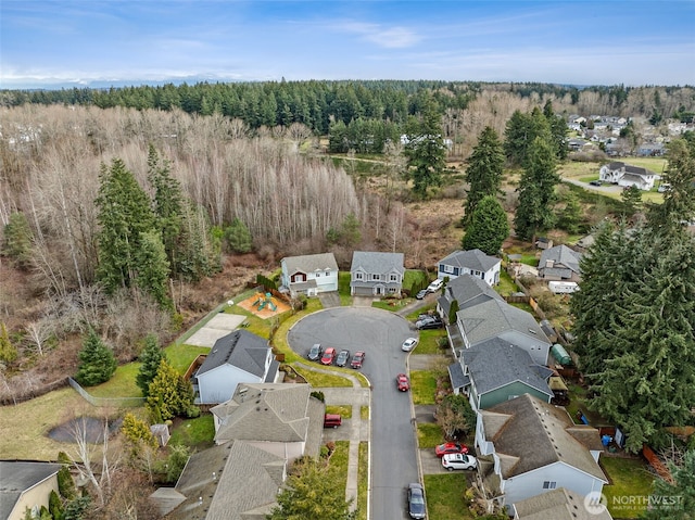 drone / aerial view with a residential view and a wooded view
