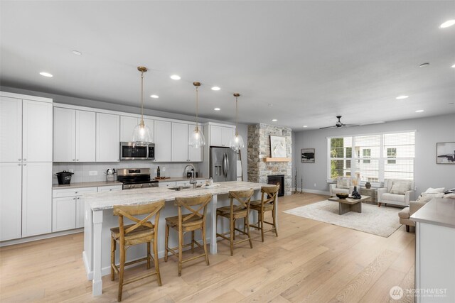 18 160th St SE, Bothell, WA 98012 - kitchen with appliances with stainless steel finishes, a spacious island, open floor plan, a ceiling fan, and recessed lighting