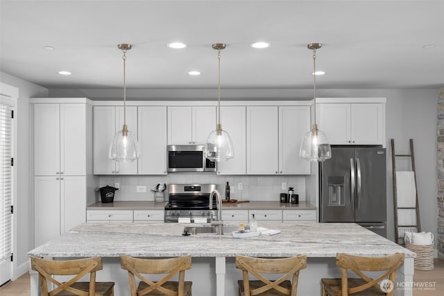 18 160th St SE, Bothell, WA 98012 - kitchen featuring stainless steel appliances, a kitchen bar, tasteful backsplash, hanging light fixtures, and recessed lighting