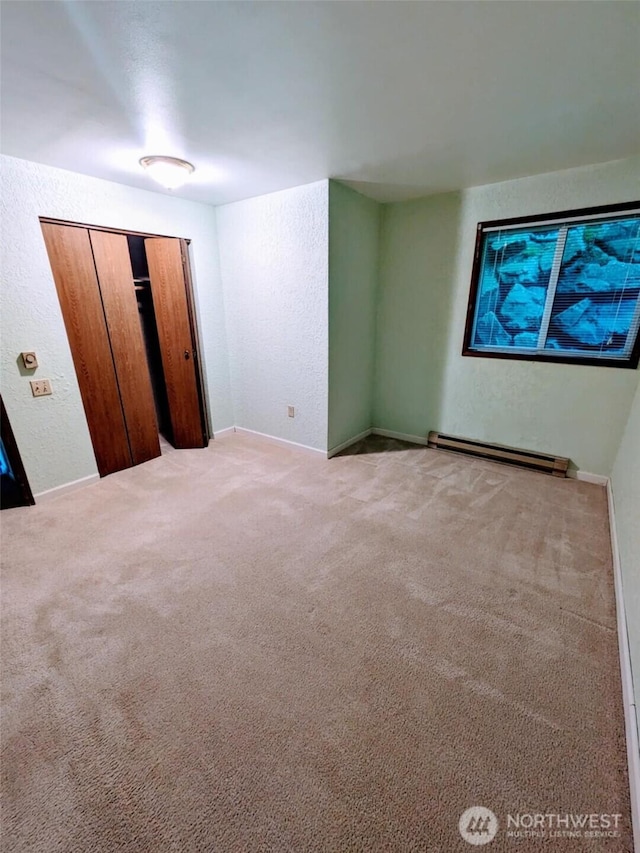140 Summit Ave N Unit B2, Kent, WA 98030 - unfurnished bedroom with a baseboard radiator, light colored carpet, baseboards, and a closet