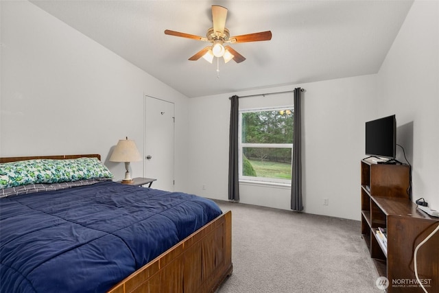 bedroom featuring vaulted ceiling, light colored carpet, and ceiling fan