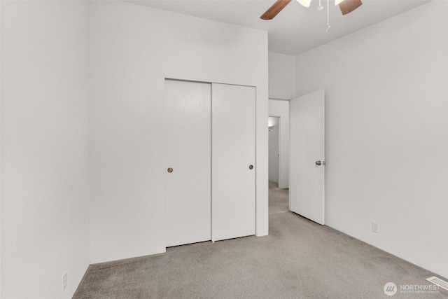 unfurnished bedroom with a closet, a ceiling fan, and carpet floors