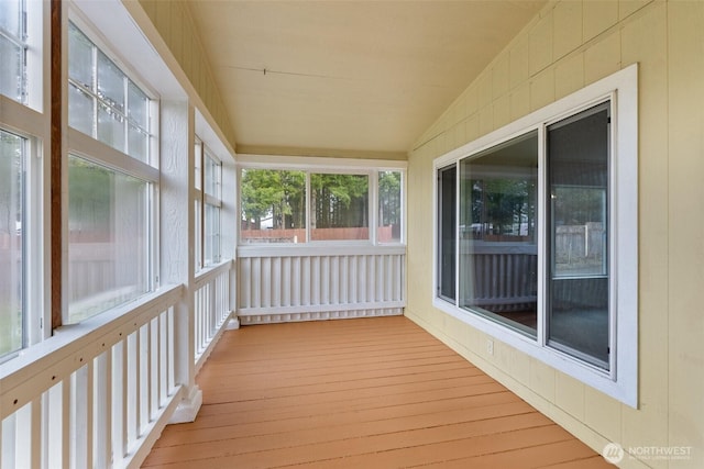 unfurnished sunroom with lofted ceiling and wood finished floors