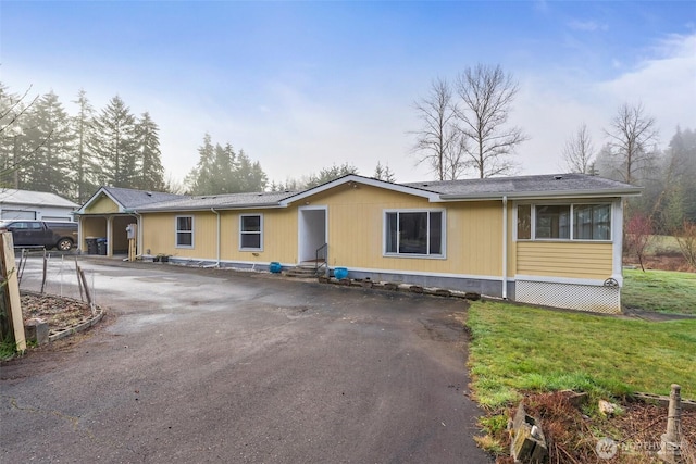view of front of home with entry steps, aphalt driveway, and a front yard