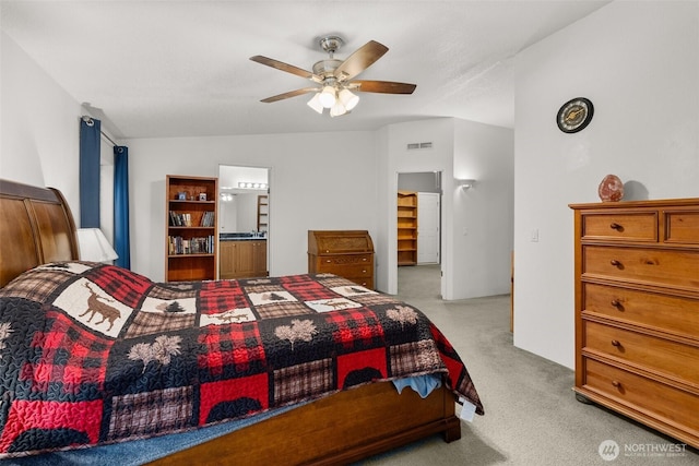 bedroom with visible vents, light colored carpet, connected bathroom, and a ceiling fan