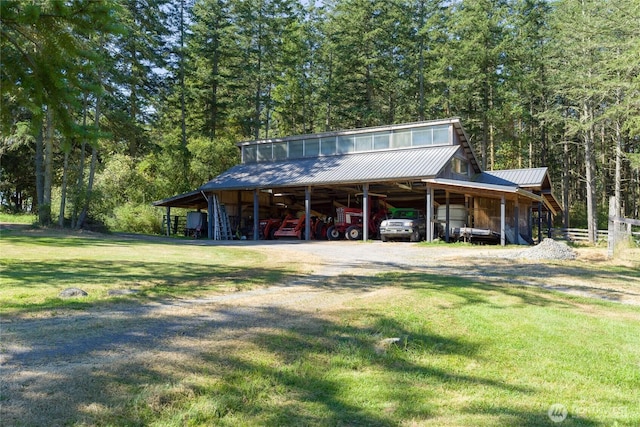 631 Cousins Rd, Lopez Island, WA 98261 - view of front of house featuring an outbuilding, a front yard, a wooded view, and driveway