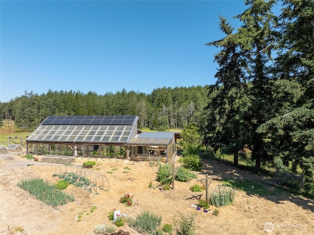 631 Cousins Rd, Lopez Island, WA 98261 - back of property featuring an outbuilding, an exterior structure, a wooded view, and solar panels