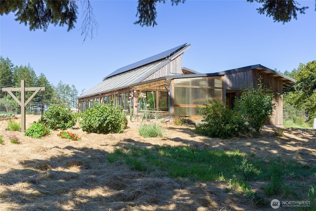 631 Cousins Rd, Lopez Island, WA 98261 - view of property exterior with an exterior structure, metal roof, an outbuilding, and solar panels