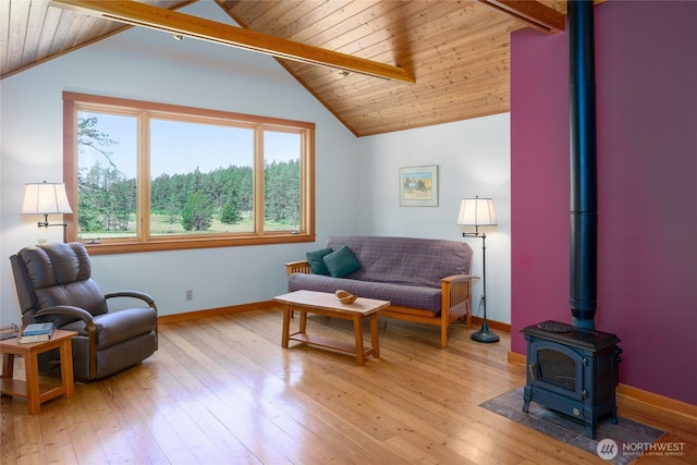631 Cousins Rd, Lopez Island, WA 98261 - living room featuring light wood finished floors, vaulted ceiling with beams, baseboards, wood ceiling, and a wood stove