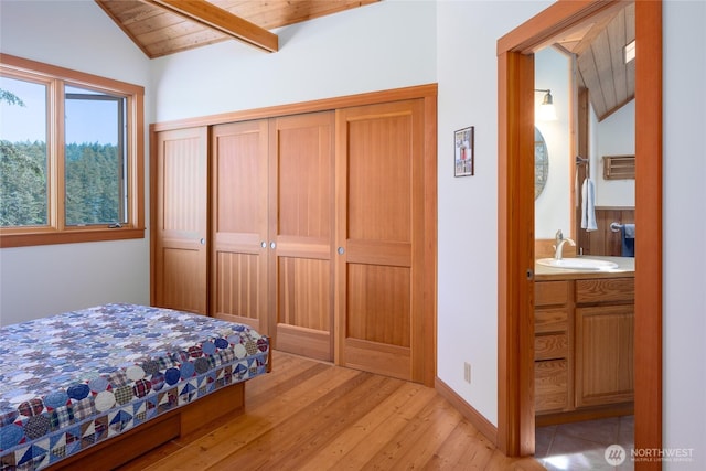 631 Cousins Rd, Lopez Island, WA 98261 - bedroom with light wood finished floors, wood ceiling, lofted ceiling with beams, a closet, and a sink