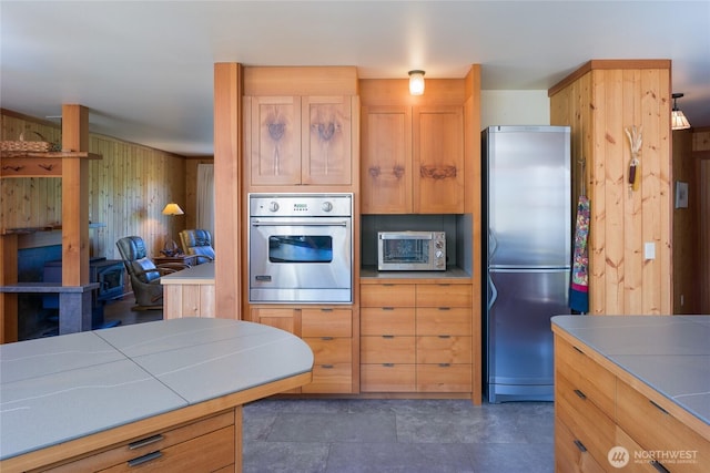 631 Cousins Rd, Lopez Island, WA 98261 - kitchen featuring tile countertops, a toaster, wood walls, and appliances with stainless steel finishes
