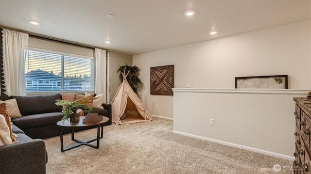 living area featuring recessed lighting, baseboards, and light colored carpet