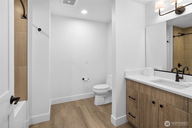 bathroom featuring visible vents, toilet, wood finished floors, baseboards, and walk in shower
