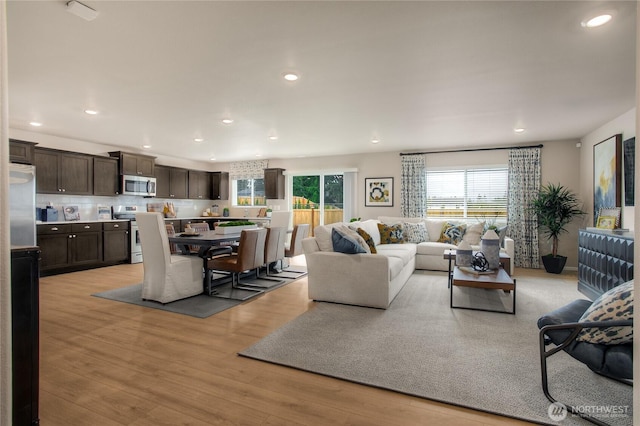 living area with light wood finished floors and recessed lighting