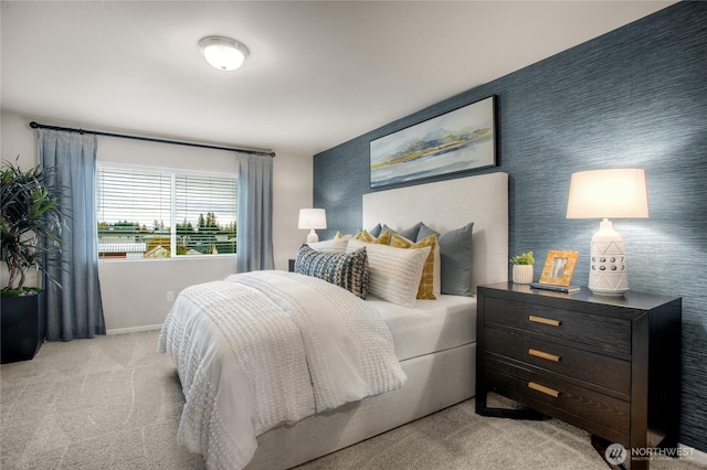 bedroom featuring light carpet, wallpapered walls, an accent wall, and baseboards