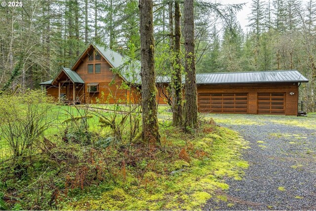 1261 Mathews Rd, Washougal, WA 98671 - view of front of property featuring a forest view, a metal roof, gravel driveway, and an outbuilding