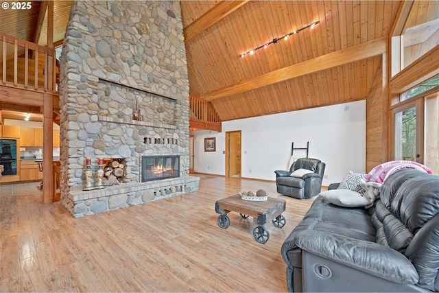 1261 Mathews Rd, Washougal, WA 98671 - living area with high vaulted ceiling, track lighting, wood finished floors, a wood ceiling with exposed beams, and a stone fireplace