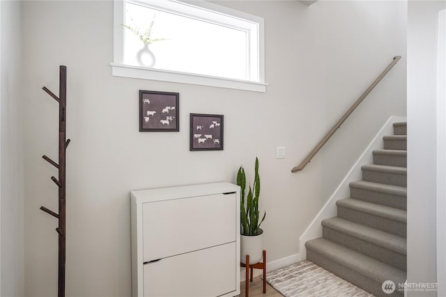 staircase featuring baseboards and wood finished floors