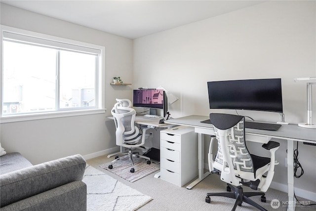 home office with baseboards and light colored carpet