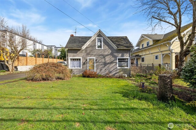view of front of property with a front yard and fence