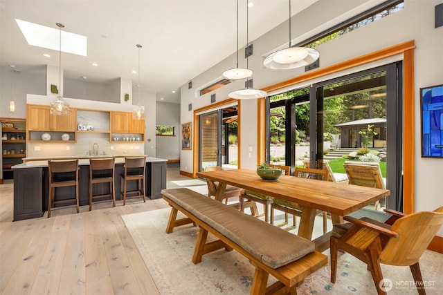 11012 Skinner Rd NE, Bainbridge Island, WA 98110 - dining space with a skylight, light wood-style flooring, and recessed lighting
