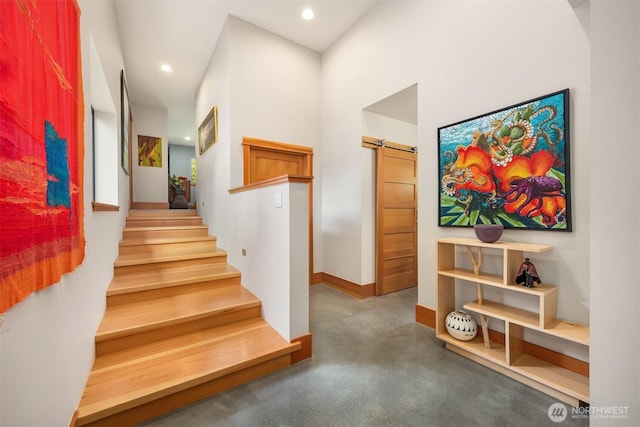 11012 Skinner Rd NE, Bainbridge Island, WA 98110 - stairs featuring a barn door, concrete floors, recessed lighting, baseboards, and a high ceiling