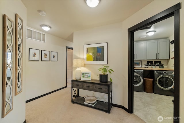 hallway with baseboards, visible vents, and light carpet