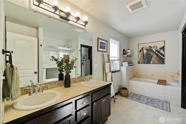 bathroom featuring a garden tub, a stall shower, visible vents, and a sink