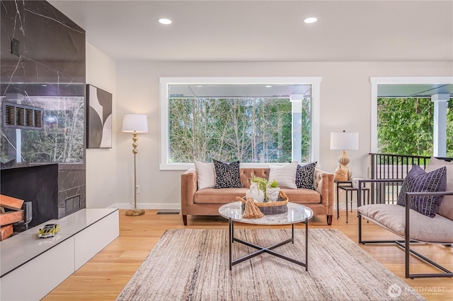 living area with recessed lighting, baseboards, and wood finished floors