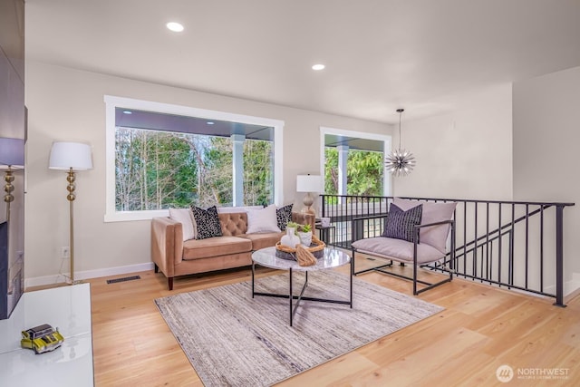 living area with wood finished floors, baseboards, and recessed lighting