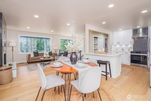 dining space with light wood-type flooring and recessed lighting