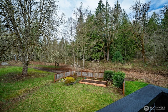 view of grassy yard featuring a vegetable garden