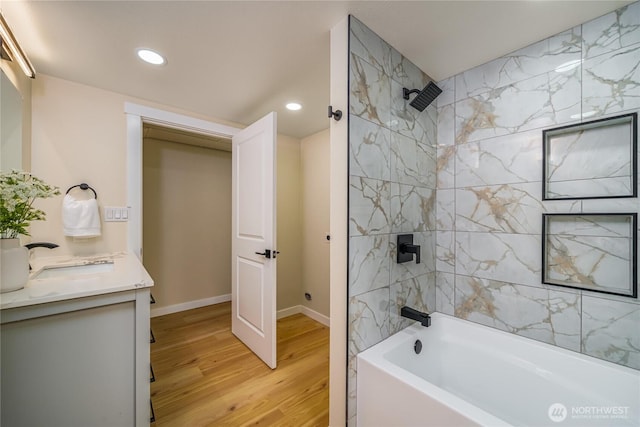 bathroom with wood finished floors, recessed lighting, tub / shower combination, vanity, and baseboards