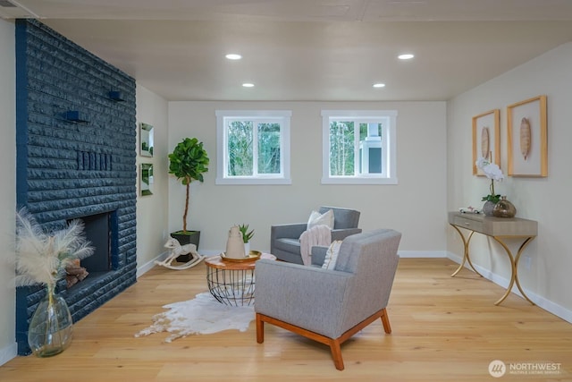 living room with wood finished floors, baseboards, a fireplace, and recessed lighting