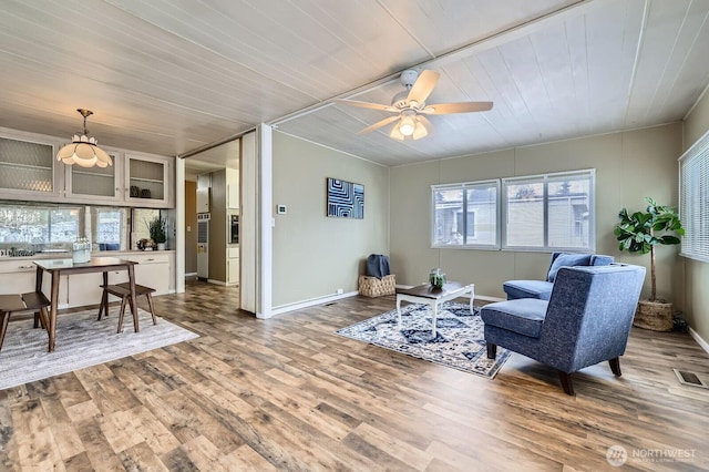 living area featuring a ceiling fan, wood finished floors, visible vents, baseboards, and wood ceiling