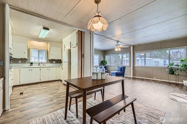 dining space featuring wooden ceiling, light wood-style flooring, a ceiling fan, and visible vents