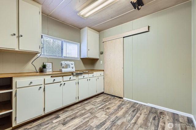 kitchen with light wood-style flooring, light countertops, and white cabinetry