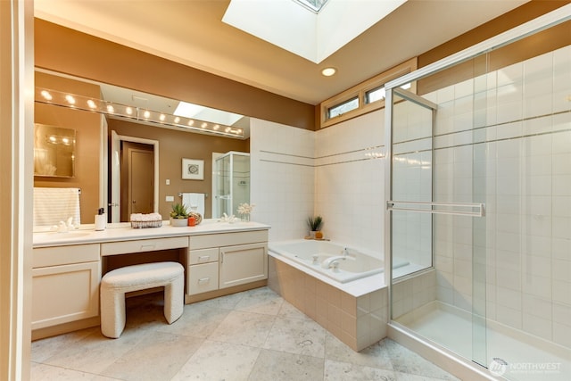 full bathroom featuring a shower stall, double vanity, a skylight, a bath, and a sink