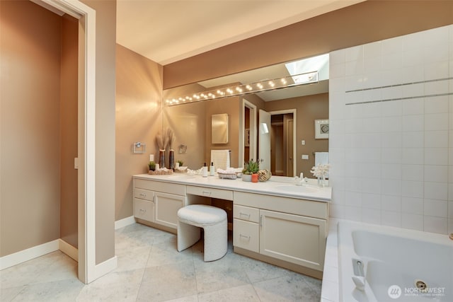 bathroom featuring a whirlpool tub, a skylight, tile patterned flooring, baseboards, and vanity