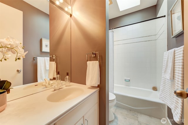bathroom featuring a skylight, shower / bath combination with curtain, toilet, and vanity