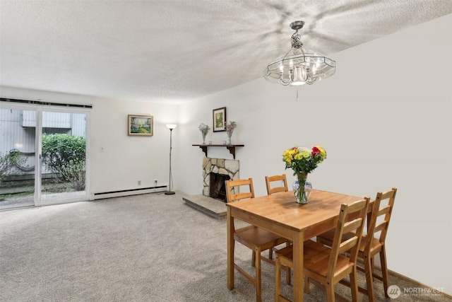 carpeted dining room featuring baseboard heating, a textured ceiling, and a fireplace