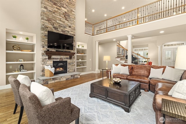 living room featuring stairway, built in shelves, baseboards, and wood finished floors